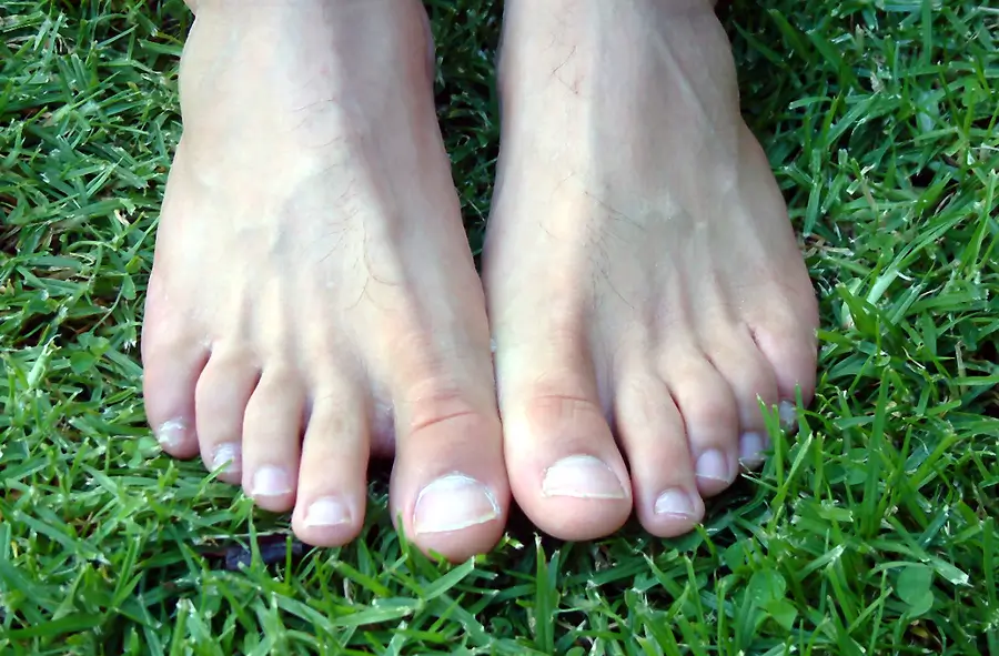 Feet on a background of green grass